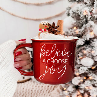 red ceramic mug that says believe and choose joy for Christmas
green Christmas coffee mug with inspirational holiday saying
cute festive mug for drinking coffee by the Christmas tree
cozy ceramic Christmas cup for hot chocolate and winter drinks
farmhouse style Christmas mug for kitchen decor