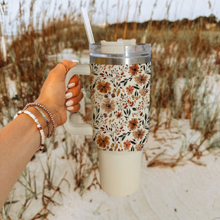 neutral floral tumbler for cozy mornings
autumn floral tumbler with reusable straw
fall inspired wildflower cup
beige pumpkin spice aesthetic tumbler
cute floral hydration tumbler for women
neutral floral latte tumbler
cozy botanical fall cup
autumn floral tumbler for busy moms