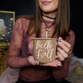 hello fall mug next to autumn scented candle
hello fall mug with acorns and pinecones decor
hello fall latte mug with frothy milk art
hello fall mug styled in farmhouse hutch