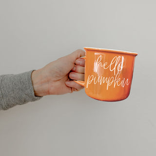 pumpkin colored coffee cup and donut
fall inspired mug with warm brown tones
orange ceramic drinkware for seasonal lattes
autumn shelf styling with orange coffee cup