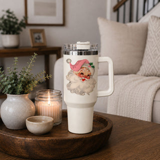 vintage Christmas tumbler in festive living room
Santa tumbler styled with pine and berries
pink Santa cup beside holiday candle
retro Santa drinkware with wreath decor
Christmas tumbler with warm holiday background
vintage Santa cup in traditional Christmas setting
pink Santa tumbler with cozy blanket background
festive Santa drinkware in winter home decor
retro Santa tumbler photographed in Christmas kitchen
vintage Santa product lifestyle image
pink Santa Christmas product photo
retro Santa tumbler style
