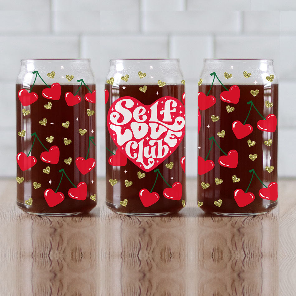 Red heart and gold glitter 20oz glass cups with bamboo lid and glass straw for a trendy gift.
"Self Love Club" 20oz glass cups with bamboo lid, glass straw, and retro cherry heart graphics.