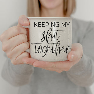 Keeping My Shit Together” 14oz speckled ceramic coffee mug with double-sided motivational saying, held by a woman.