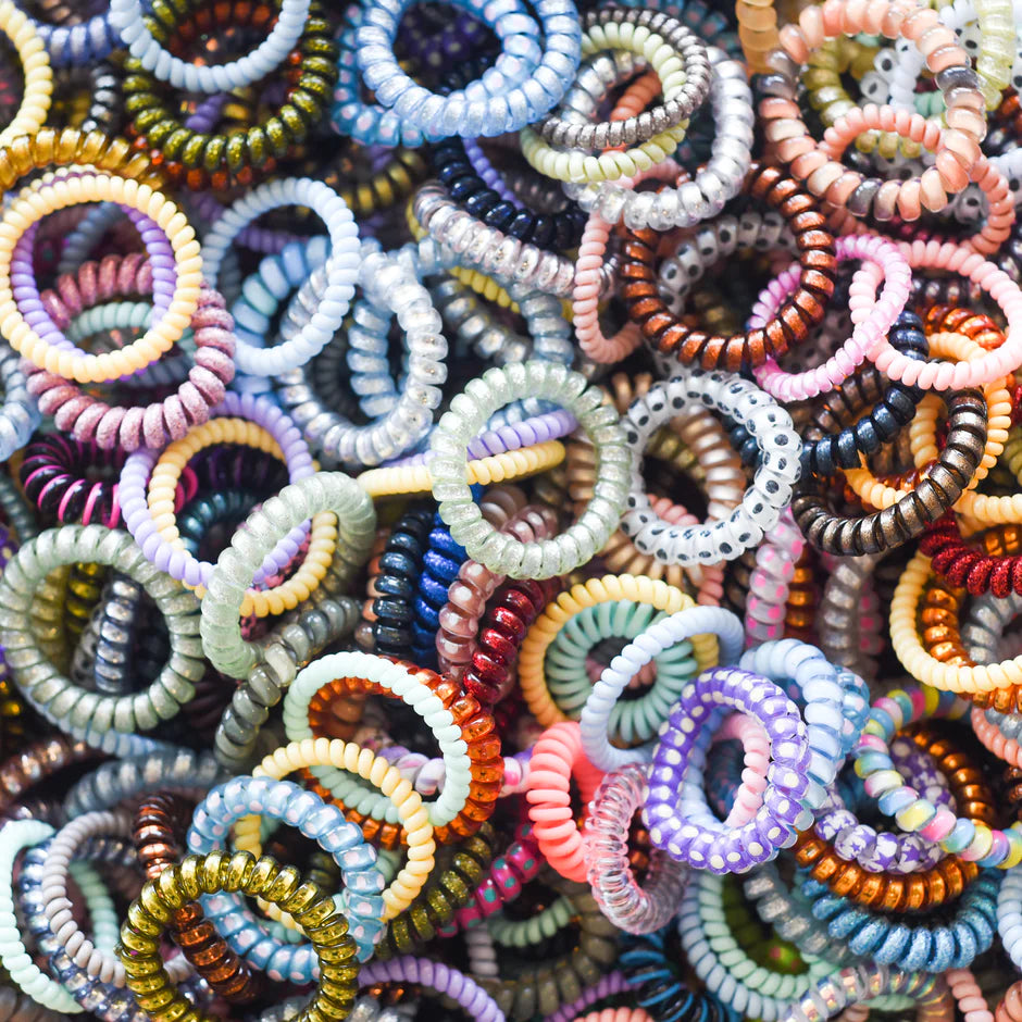 a pile of multicolored bracelets sitting on top of each other