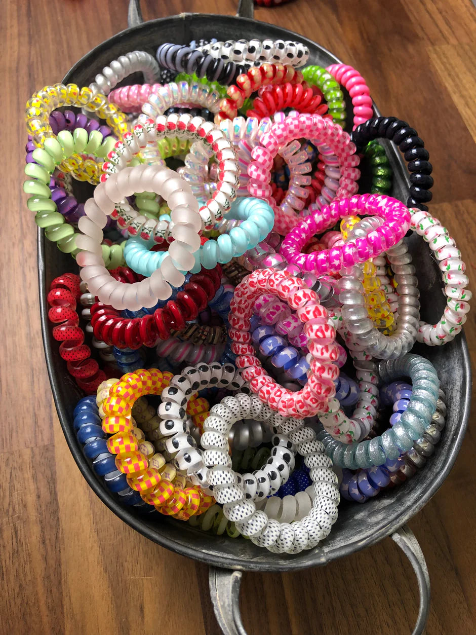 a bunch of bracelets in a bowl on a table
